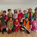 Groupe de clowns de la Zanni Compagnie de théâtre, costumes colorés et rieurs.