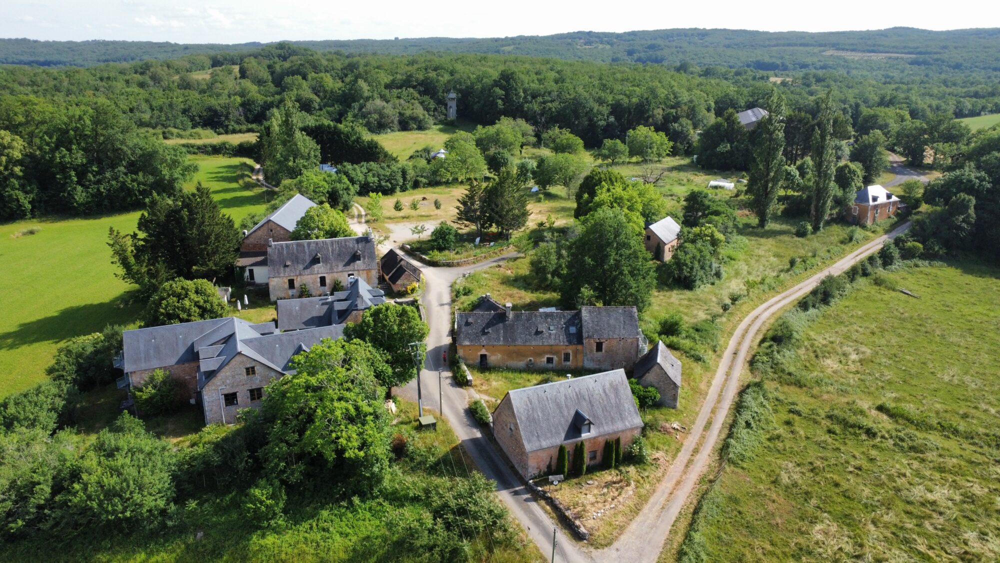 Village rural avec bâtiments en briques et chemins de terre.