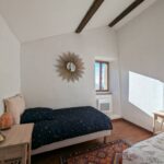 Chambre avec deux lits simples et miroir mural soleil